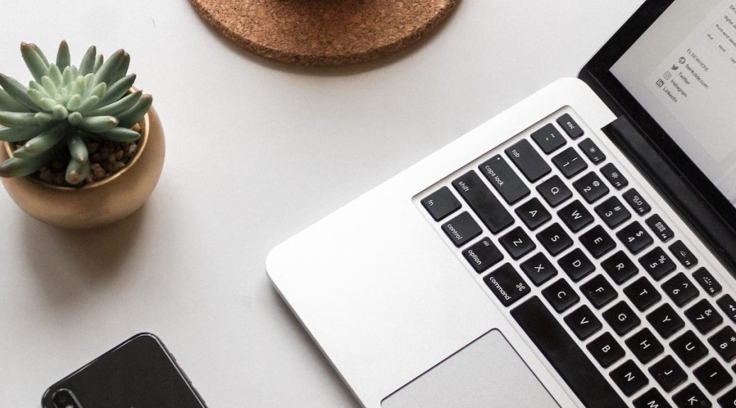 space gray iPhone X beside turned on laptop beside coffee and succulent plant