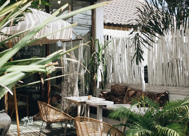 white table with brown wicker chair beside plants