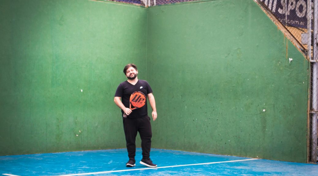 a man standing on a tennis court holding a racquet