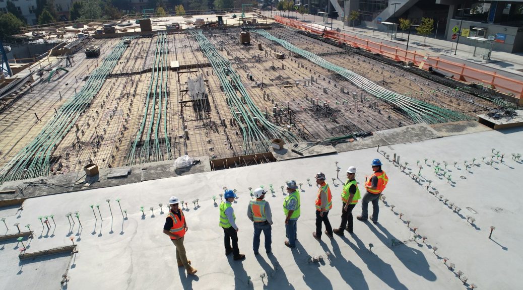 seven construction workers standing on white field